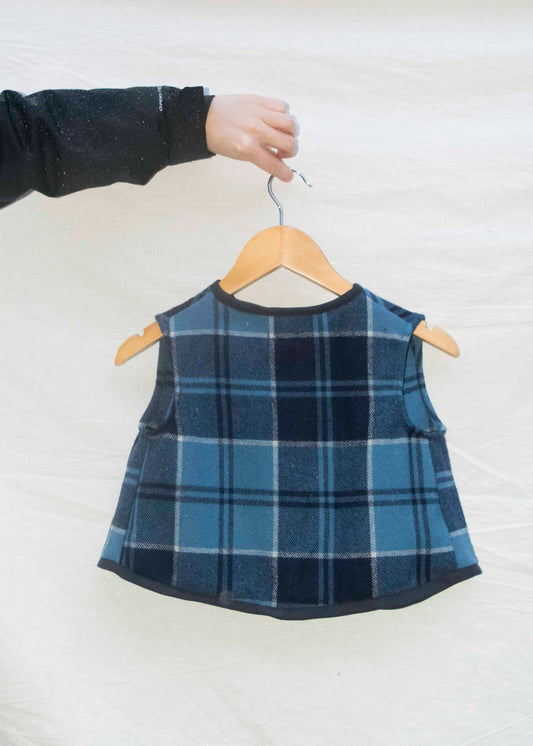 Mini gilet in blauwe ruit, achteraanzicht op hanger