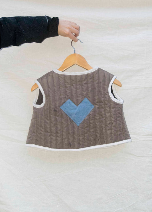 Mini gilet taupe gequilt met denim hartje op de rug, achteraanzicht