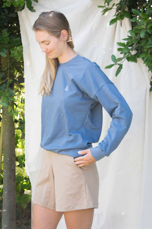 Room oversized sweater in grijsblauw, detail van de ruime mouwen en klein logo