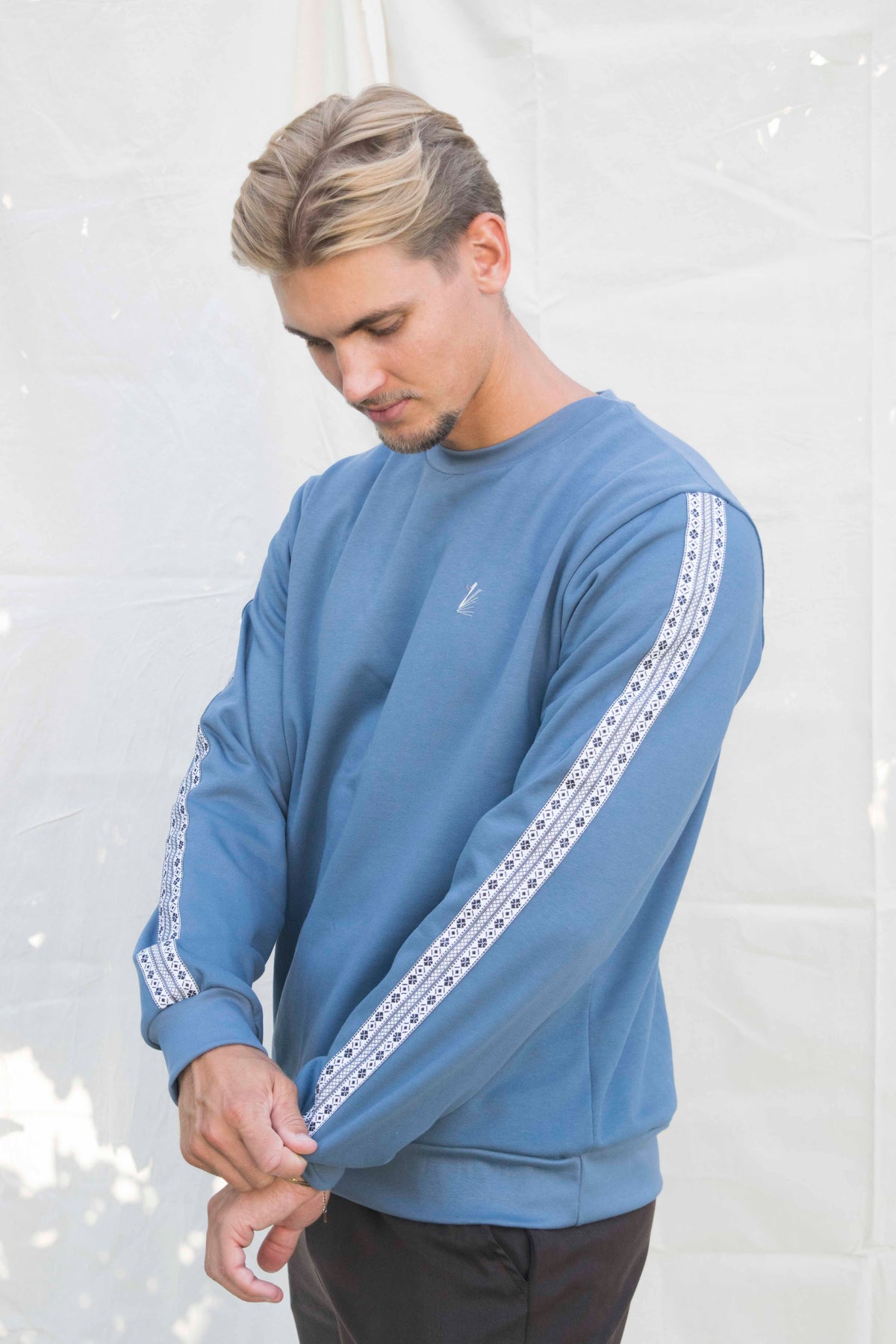 Basic sweater unisex middenblauw, detail van de schortenbont-band op de mouw