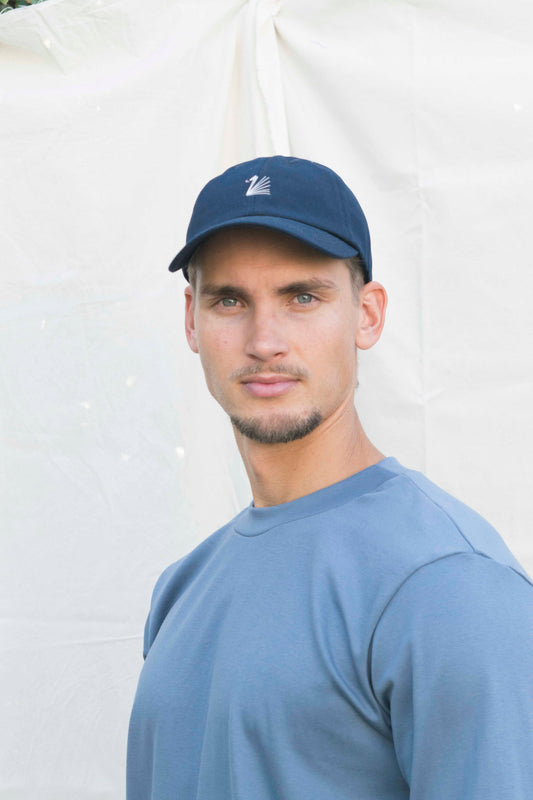 ZWAAN pet in donkerblauw met handgestikt wit zwaan-logo, vooraanzicht